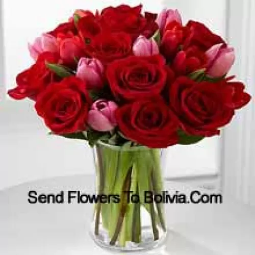 11 rote Rosen und 6 rosa Tulpen mit einigen saisonalen Füllern in einer Glasvase
